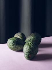 Avocados on purple and gray background