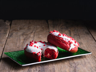 Pair of doughnuts, one of them bitten, on a green tray, close up