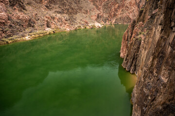 Calm Waters Of The Colorado River Turns The Corner Around A Tall Cliff