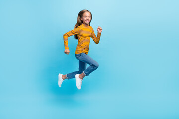 Fototapeta na wymiar Full size profile portrait of carefree cheerful girl jumping run hurry isolated on blue color background