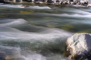 In the long exposure picture, the water of the river appears to be uniformly stagnant.