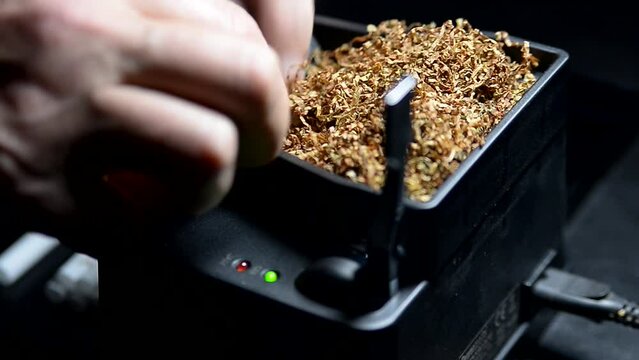 The process of putting tobacco into cigarette cases with a semi-automatic machine