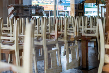 Wooden chairs on the tables of an empty and closed restaurant