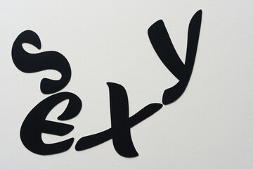 black paper letters on blank paper (reads: sexy)