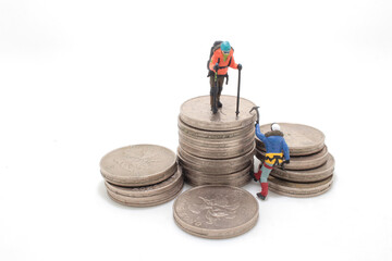 a mini climbers team climbing on stack of coins