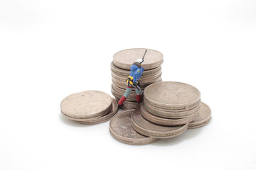 a mini climbers team climbing on stack of coins
