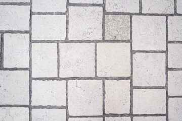 Gray brick stone outdoor top view background. Square pavement tiles texture close-up.