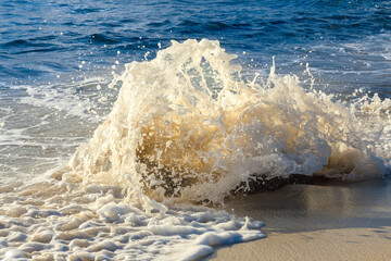Espuma de la ola al golpear con una roca 