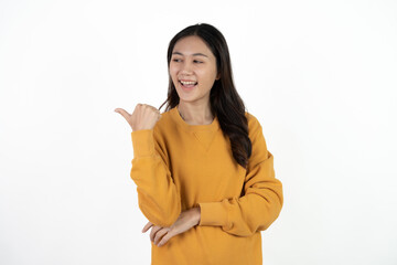 Young beautiful Asian businesswoman smiling and pointing to empty copy space isolated on white background.