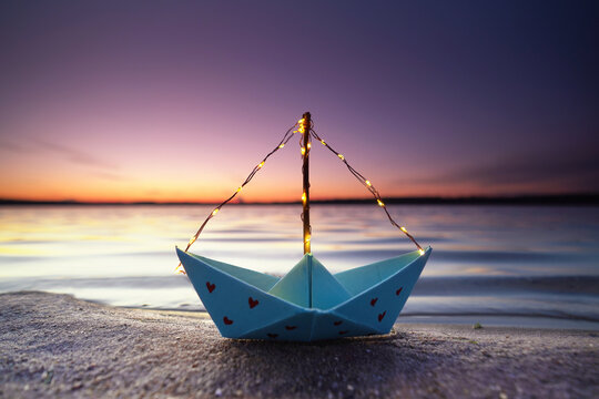 romantisches Papierboot am Strand
