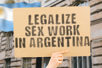 The phrase " Legalize Sex Work in Argentina " is on a banner in men's hands with blurred background. Guide. Govern. Body. Coworker. Crime. Criminal. Democracy. Desire. Employee. Earnings. Dollars