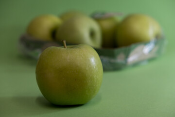 A Whole and a slice of apple on a black background, side view, Green apples, fresh, isolated on black, sliced apple on a stick