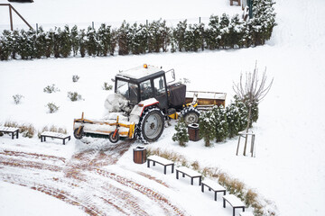 Tractor sweep snow with rotating brush and snowplow from pedestrian zone on bridge, sidewalk snow...