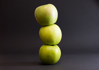 A Whole and a slice of apple on a black background, side view, Green apples, fresh, isolated on black, sliced apple on a stick