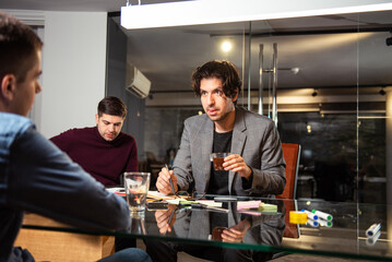 Mixed group of business people sitting around a table and talking