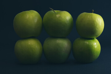 A Whole and a slice of apple on a black background, side view, Green apples, fresh, isolated on black, sliced apple on a stick