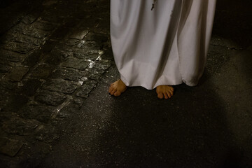 feet of a prophet walking barefoot, following the faith of Jesus, believing person of a religion in act of promise. holy week in spain. High quality photo horizontal - obrazy, fototapety, plakaty