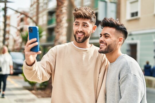 Young couple standing together making selfie by the smartphone at street