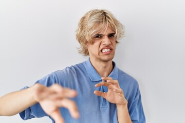 Young modern man standing over isolated background disgusted expression, displeased and fearful...