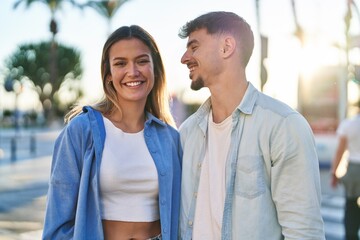 Fototapeta premium Young man and woman couple smiling confident standing together at street