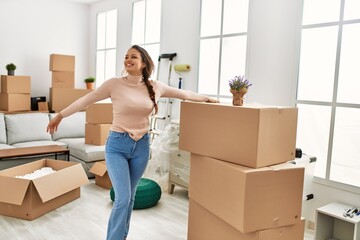 Young beautiful hispanic woman smiling confident standing at new home