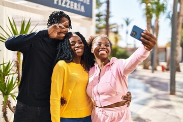 African american friends standing together making selfie by the smartphone at street