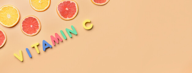 Text VITAMIN C and citrus fruit slices on orange background with space for text