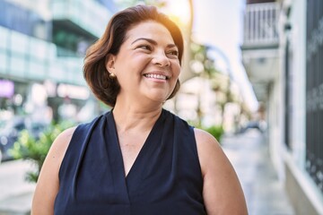 Middle age hispanic woman smiling happy and confident outdoors on a sunny day