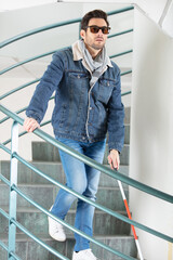 blind man going down the stairs holding cane