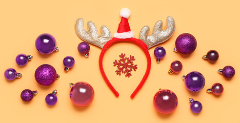 Funny Christmas reindeer horns and stylish balls on color background