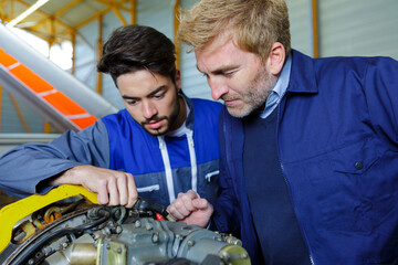 men working on engine of the airplane