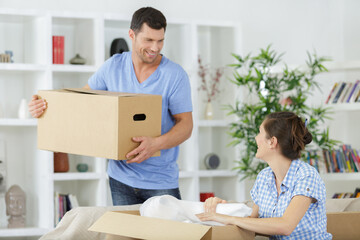 Fototapeta na wymiar couple unpacking boxes in kitchen on moving day