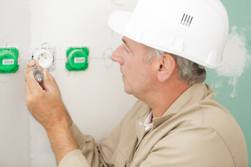 electrician installing socket in new house