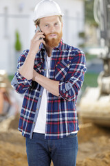 bearded tradesman outdoors using smartphone