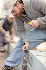 builder using plumb weight on construction site