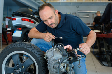 Fototapeta na wymiar a man fixing a motorcycle in garage