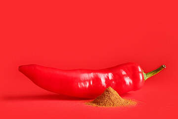 Red chili pepper and powder on color background