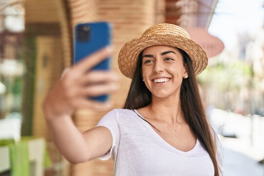 Young hispanic woman tourist smiling confident making selfie by the smartphone at street