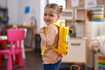 Adorable hispanic girl student smiling confident wearing backpack at kindergarten
