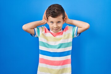 Young caucasian kid standing over blue background doing bunny ears gesture with hands palms looking cynical and skeptical. easter rabbit concept.