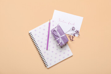 Composition with card, gift box, notebook and pencil on color background