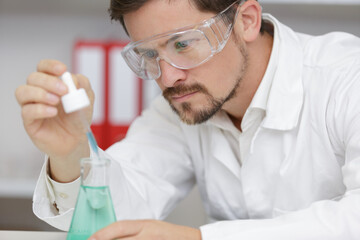 man is looking into the glass of microscope doing reseach