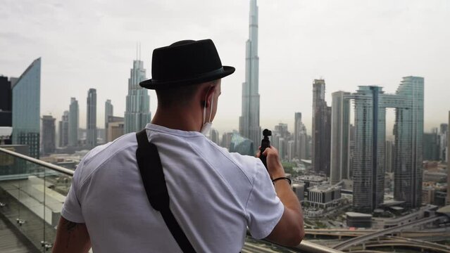 Photographer using light meter on skyscraper