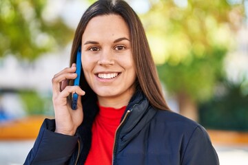 Young beautiful hispanic woman smiling confident talking on the smartphone at park