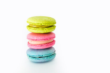 Brightly colored stacked up macarons on white. Tasty colourful macaroons. Blue, pink and green macaroons isolated on white background. French pastry made from egg whites. Concept of food, desserts