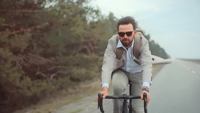 Man in business suit hurrying to work on bicycle 