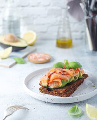 A rye bread sandwich with avocado and salmon
