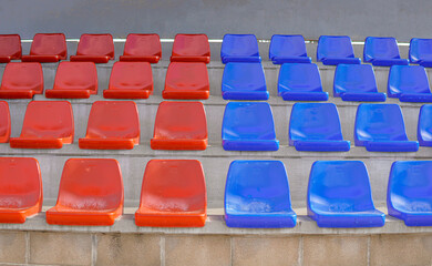 Fototapeta premium Symmetry tier of empty blue and red seats on a soccer field. Seats in the colors of Barça.