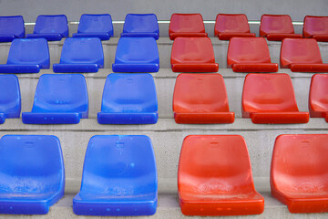 Symmetry tier of empty blue and red seats on a soccer field. Seats in the colors of Barça in...