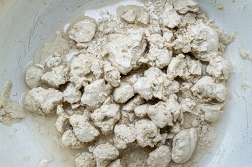 close up of wet white clay in a bowl